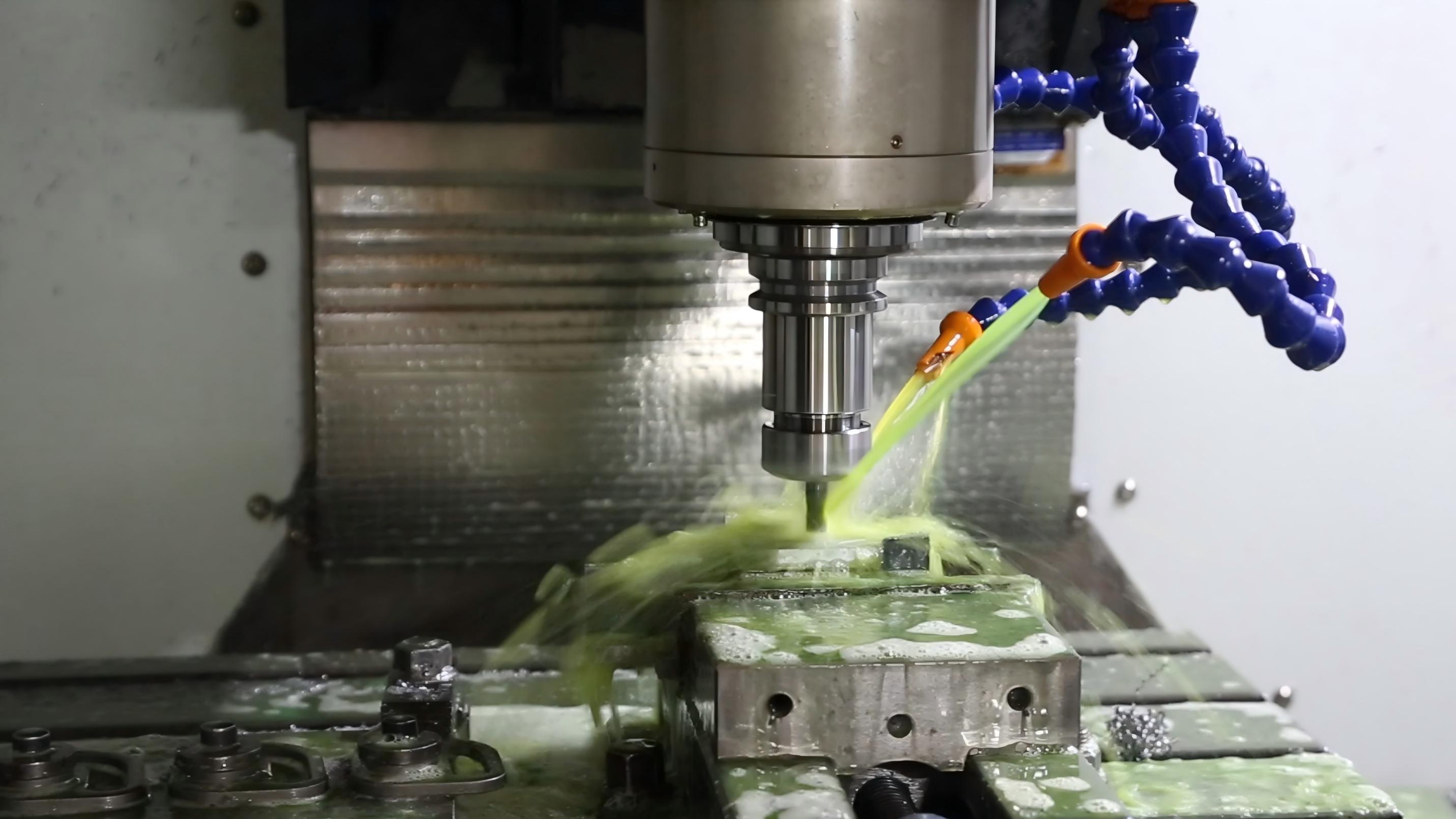 CNC machine cutting a precision steel component with coolant applied